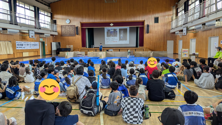 体育館で説明を聞く子どもたちの写真